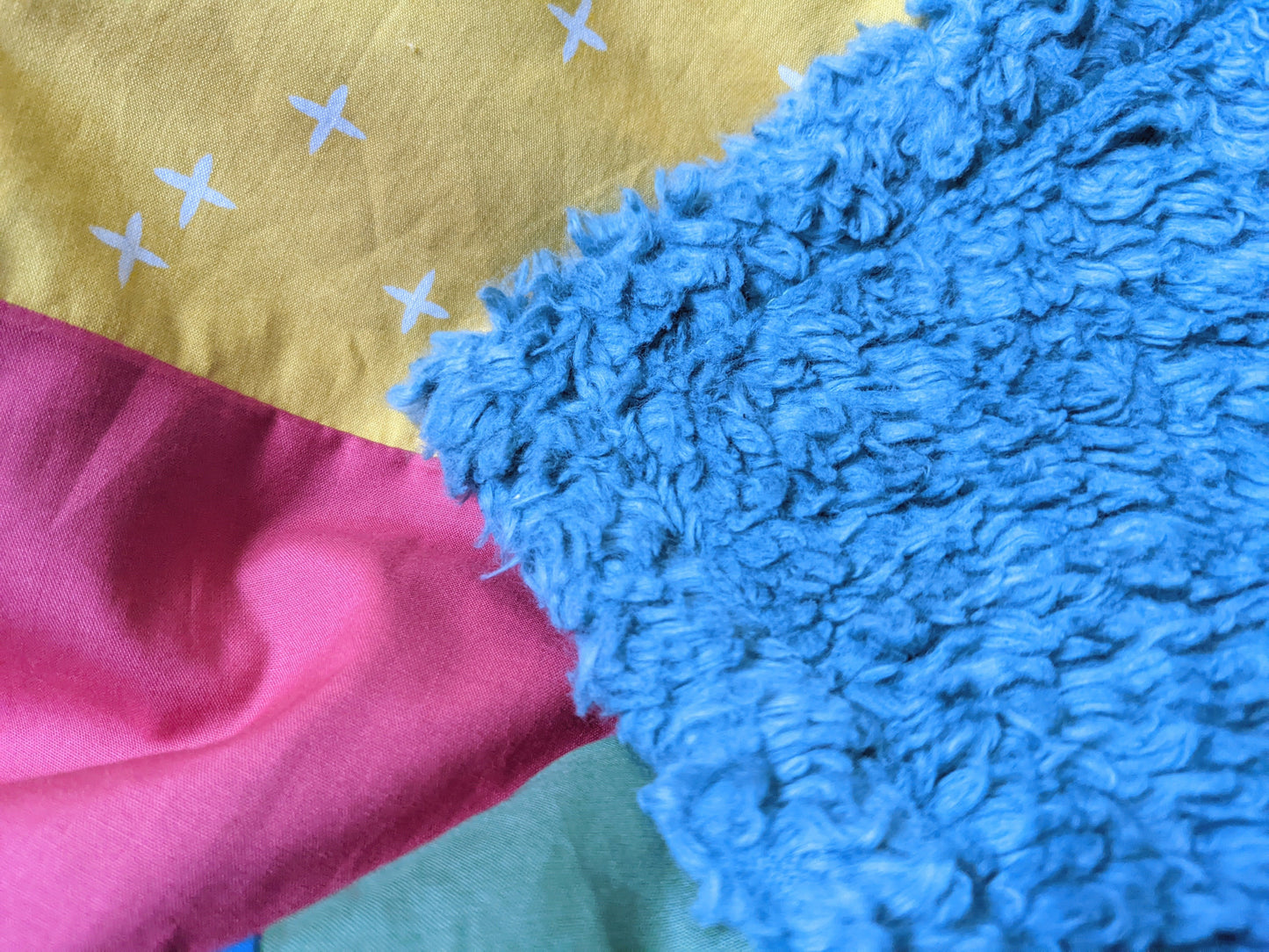 Baby Peipei backing for bright patchwork quilt. A blue shaggy sherpa made from 100% organic cotton