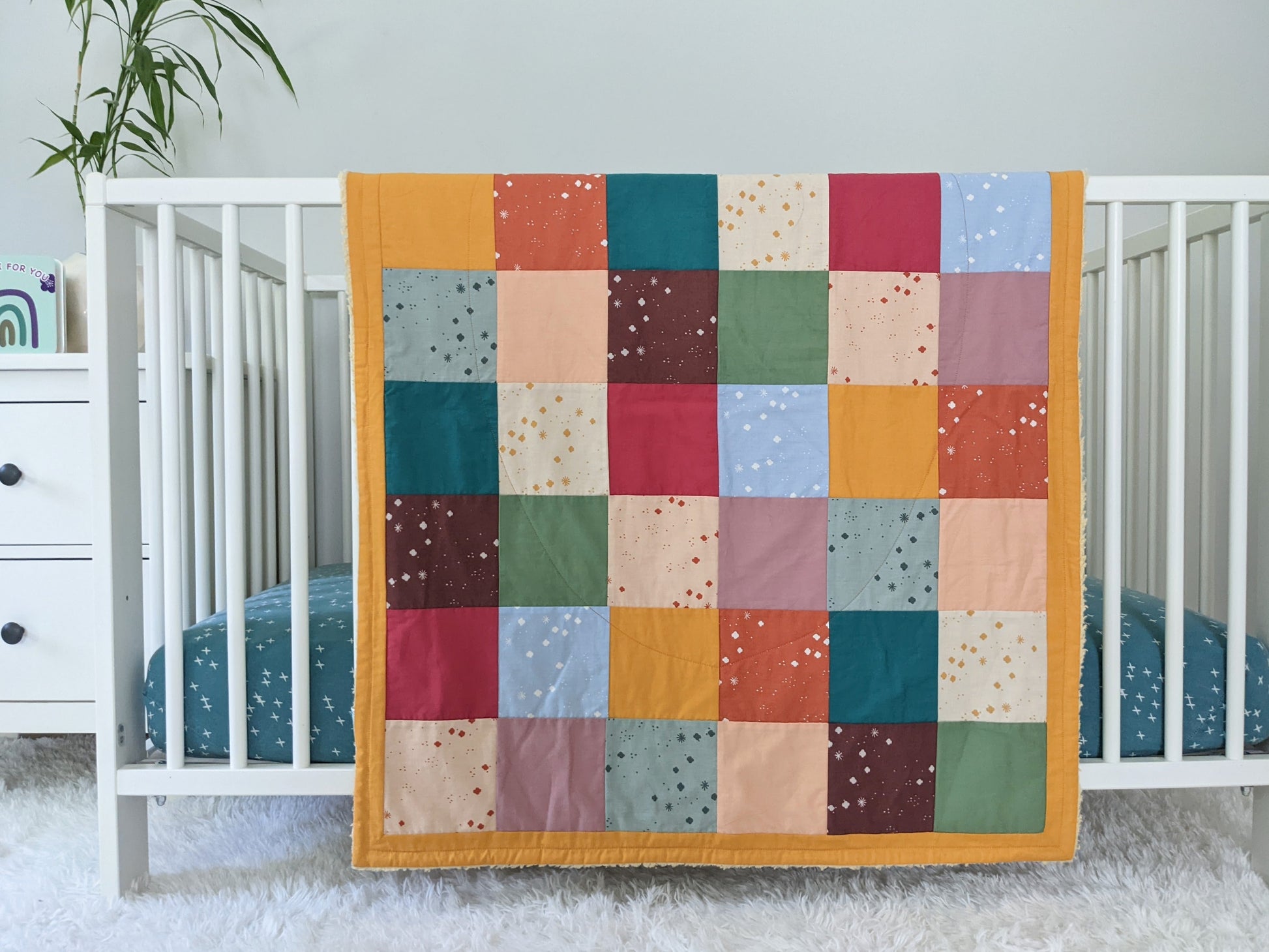 Baby Peipei 's organic patchwork quilt with pastel and earth tones. This quilt is crib sized. With 12 fabrics, this quilt is reminiscent of the Bai Jia Bei Chinese quilt tradition 