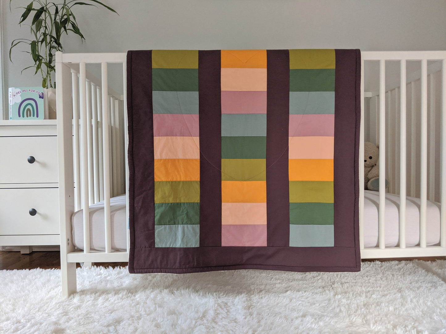 Boho Rainbow on Huckleberry, Original size, backed with Fluffy Sherpa hanging over a crib side